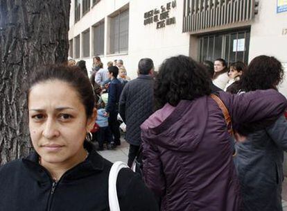 Una inmigrante paraguaya espera ante un colegio de Madrid a los niños a los que cuida.