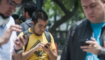 Un grupo de paseantes utiliza su celular en Ciudad de México.