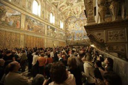 Una multiutud de turistas contemplan los frescos de Miguel Ángel.