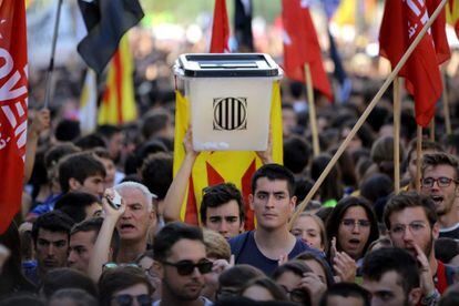 Un estudiante porta una urna como las usadas en octubre de 2017 durante el referéndum independentista. En la imagen, concentración de estudiantes en la Plaza Universidad en Barcelona.
