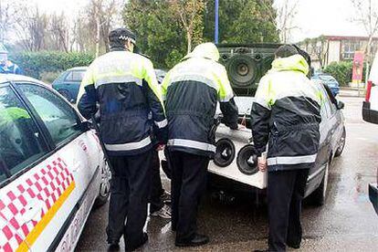 Tres policías de Sevilla requisan los altavoces de un <i>coche-discoteca</i>.