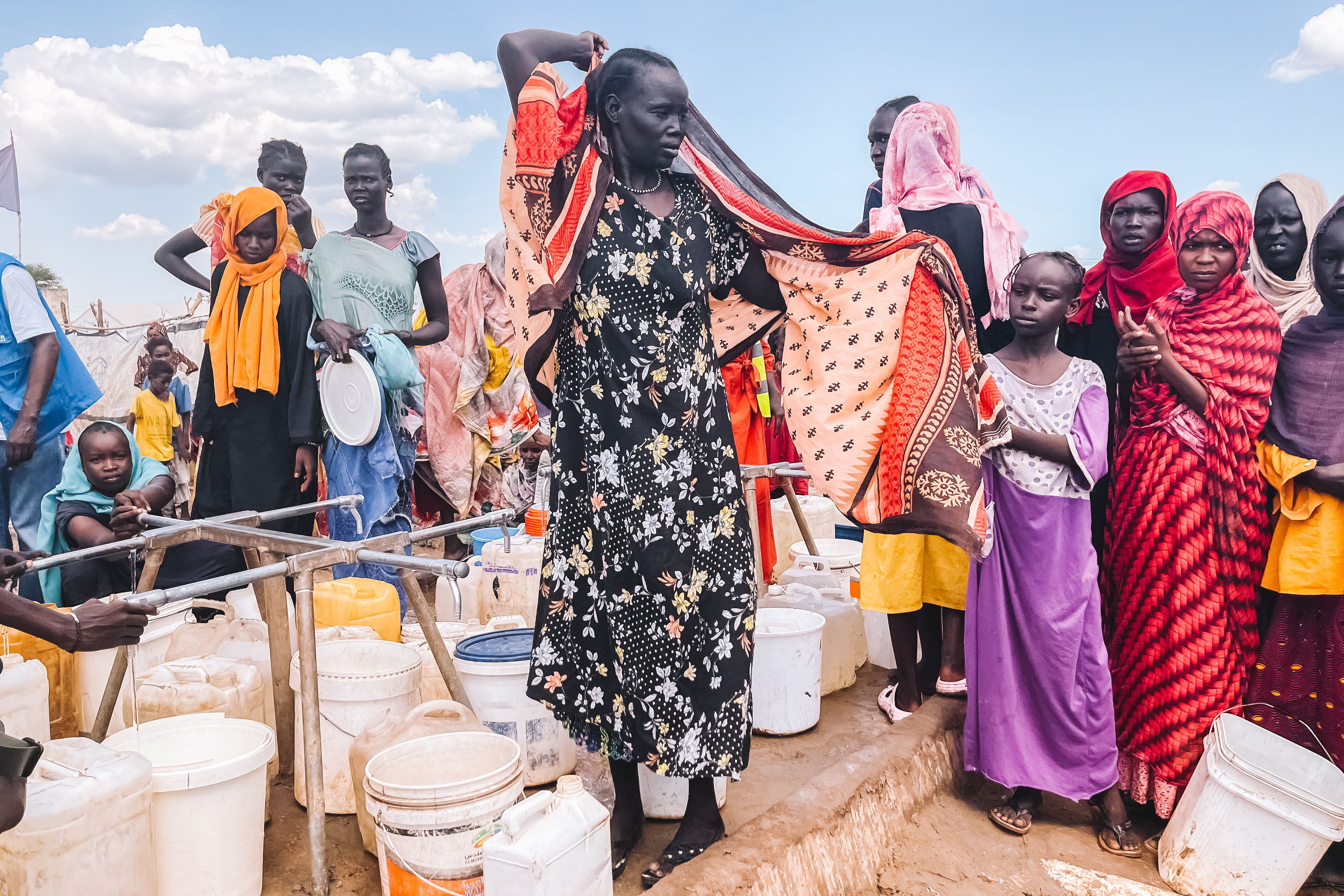 Varias mujeres refugiadas hacen cola para obtener agua limpia en uno de los puntos de suministro del centro de tránsito de Renk, en Sudán del Sur.