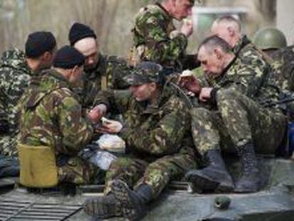 Soldados ucranianos comen subidos a un veh&iacute;culo blindado en Kramatorsk.