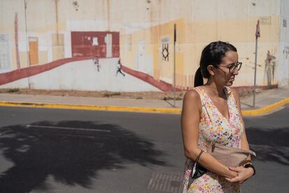 Sheyma Mohamed fotografiada frente a la pintura en la pared del presidio de Melilla, una creación obra de los propios internos que imita el aspecto de una calle.
