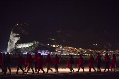 Immigrants subsaharians caminen cap al Centre d'Atenció Temporal d'Estrangers des del moll situat a Crinavis (Algesires, Cadis). Al fons, el penyal de Gibraltar, el 15 d'agost del 2018, en una jornada en la qual es van rescatar 524 migrants al mar d'Albóran i en aigües de l'Estret.