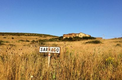 Señal que marcaba el paso por la localidad de Sarnago (Soria), con algunas casas al fondo.