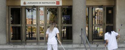 Dos limpiadoras barren el acceso a los juzgados de la plaza de Castilla. 
