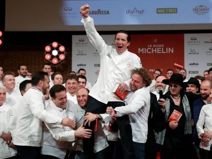 Christophe Bacqui&eacute;, con el pu&ntilde;o en alto, y Marc Veyrat, con el gorro negro, los dos nuevos chef de la gu&iacute;a Michelin de Francia con tres estrellas.