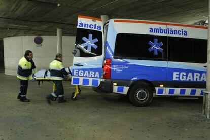 Dos treballadors al costat d'una ambulància a Terrassa.