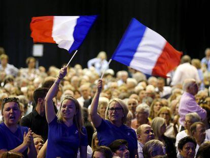 Dos simpatizantes de Fillon agitan una bandera de Francia en un mitin de campa&ntilde;a