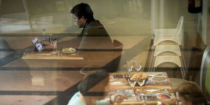 Un hombre con su tableta en un restaurante de Barcelona.