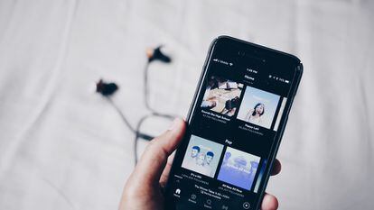 Un iPhone muestra el menú de 'podcasts' de Spotify