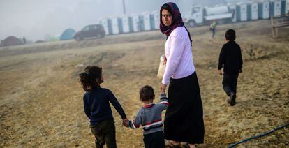 Una mujer camina con sus hijos por el campo de refugiados de Idomeni, en Grecia, este martes.