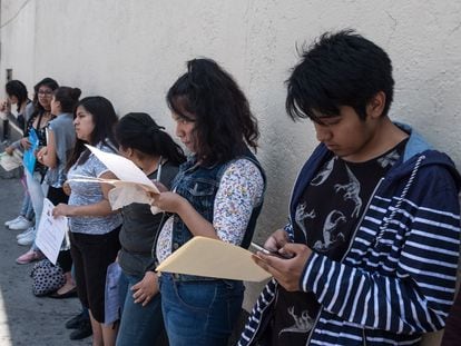 Jóvenes hacen fila para realizar el examen de ingreso a la UNAM, a las afueras de un centro educativo en Ciudad de México.