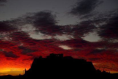 Vista de la Acrópolis con las nubes rojas durante el anochecer en Atenas (Grecia).