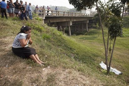 Una mujer llora junto al cuerpo del Justiniano Lara, de 51 años, después de que fuera asesinado por asaltantes no identificados en San Pedro Sula, Honduras.