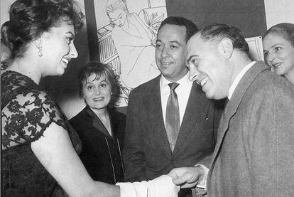 Sophia Loren con Carlo Ponti en un 'vernissage' de Novella Parigini (al fondo, a la izquierda), 1956.  La actriz siempre halló en Ponti la protección propia de un padre. Y no sólo por los 20 años de edad que los separaban, sino también porque Ponti fue quien realmente alumbró el mito Loren al colocarla en el centro de las grandes producciones italianas de la época.