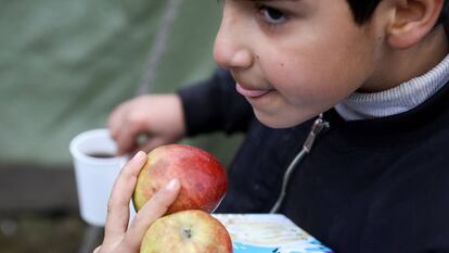 Un niño migrante lleva comida en un centro de transporte y logística cerca de la frontera entre Bielorrusia y Polonia, en la región de Grodno.
