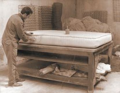 Un trabajador cierra un colchón de forma manual en 1958.