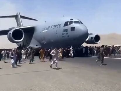 Captura de vídeo en la que se ve una multitud rodeando un avión militar de EE UU, este lunes en el aeropuerto de Kabul.