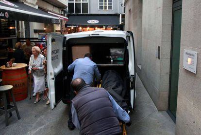 El cuerpo de la mujer asesinada en A Coruña es introducido en una furgoneta de los servicios funerarios.