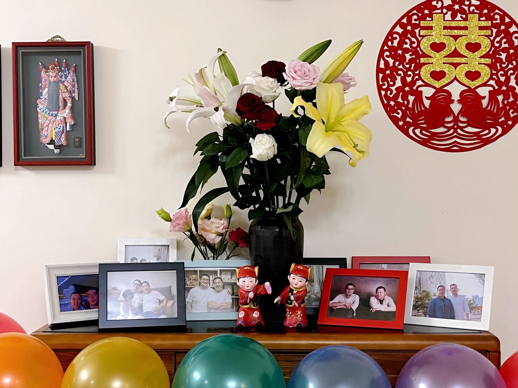 Detalle del salón de Jungang y Zhijun, donde se ven varias fotos de ambos y unos globos que este último colocó para su boda virtual.