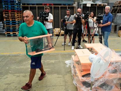 Un operario traslada urnas en los talleres municipales de Barcelona donde se prepara el dispositivo para las elecciones del próximo domingo.