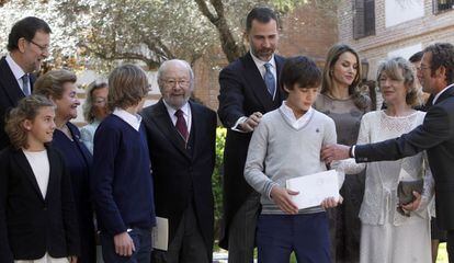 El príncipe Felipe coloca a uno de los nietos del Premio Cervantes 2012, Caballero Bonald (c), para la foto de familia, en los jardines de la Universidad de Alcalá de Henares.