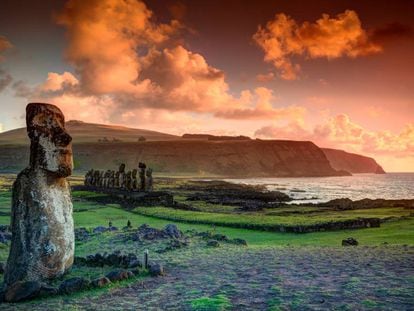 Un solitario moái y al fondo la hilera de estatuas de piedra de Ahu Tongariki, en la isla de Pascua.