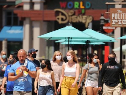 Visitantes con mascarilla en Disney Springs, en Orlando, que ha abierto parcialmente sus instalaciones.