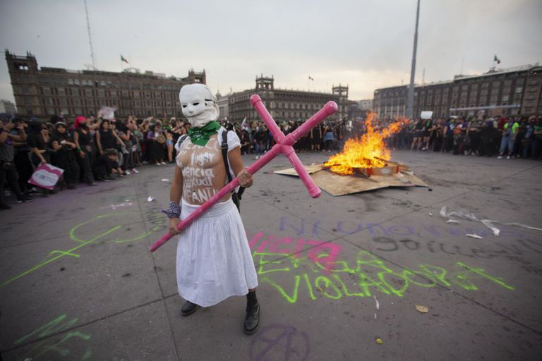 Mujer levanta cruz representante de feminicidio.