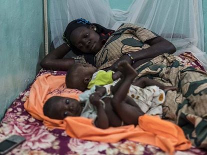 Una madre desansa junto a sus dos hijss aquejados de malnutrición en la Unidad Nutricional Intensiva del hospital Dioila el 7 de noviembre de 2016 en Dioila, Malí.