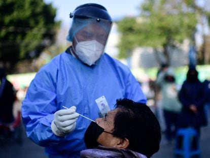 Un trabajador de la salud toma una muestra a una persona con síntomas de covid-19 en Iztapalapa, Ciudad de México, este lunes.