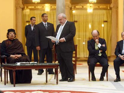 Gaddafi escucha sentado a Javier Gómez Navarro, en presencia de los empresarios Antonio Brufau y Luis del Rivero, a la derecha.