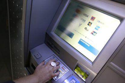 Un hombre saca euros de un cajero automático.