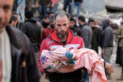 Un hombre traslada el cadáver de un menor en Jandairis (Siria).