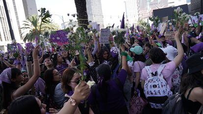 Mujeres llevan flores durante la marcha por el 8M en Ciudad de México.