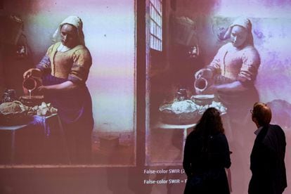 Taco Dibbits, director del Rijksmuseum (derecha) mira la proyección con los descubrimientos en torno a 'La lechera', de Johannes Vermeer, durante una rueda de prensa celebrada en Ámsterdam  este jueves.