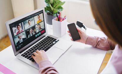 Una mujer mantiene una reunión virtual desde su casa.