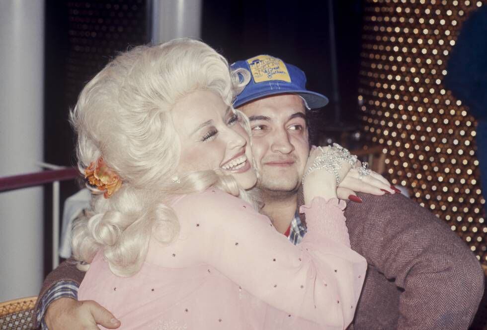 Dolly Parton abraza a John Belushi (1970). Por entonces, el dorado era el color de prestigio y Baum le pidió a Glaser que creara una cortina iluminada de cuentas de cristal, al fondo, para subrayar el aura celestial del lugar. |