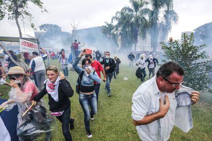Manifestantes huyen del gas lacrimógeno en Curitiba.