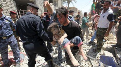 Un hombre socorre a un niño herido encontrado entre los escombros después de que un avión iraquí tirara accidentalmente una bomba en Bagdad.