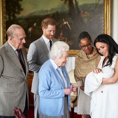 El príncipe Enrique de Inglaterra (segundo por la izquierda) y la duquesa de Sussex, Meghan Markle (a la derecha), presentan en marzo de 2019 a su hijo recién nacido, Archie Harrison Mountbatten-Windsor, a la madre de la duquesa de Sussex, Doria Ragland (segunda por la derecha), a la reina Isabel II de Inglaterra (en el centro de la imagen) y a su esposo Felipe, duque de Edimburgo, en el castillo de Windsor. 
