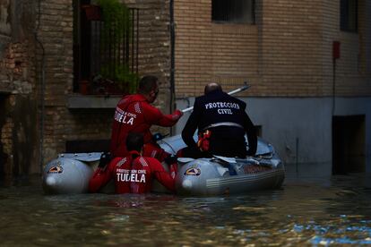 Trabajadores de Protección Civil de Tudela, en una lancha en una calle inundada de la localidad navarra, este domingo.