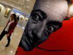 FILE PHOTO: A visitor walks past a portrait of Salvador Dali during the exhibition "Cryptography" in St. Petersburg