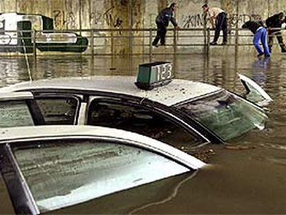 Un taxi quedó atrapado en un túnel subterráneo de Sevilla.
Dos peatones, ayer, en una calle del barrio sevillano de Los Remedios.