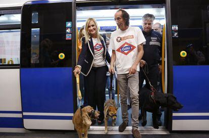 Cristina Cifuentes junto al presidente de El Refugio, Nacho Paunero, en el interior del metro con dos perritos rescatados del abandono, el 5 de julio de 2016.