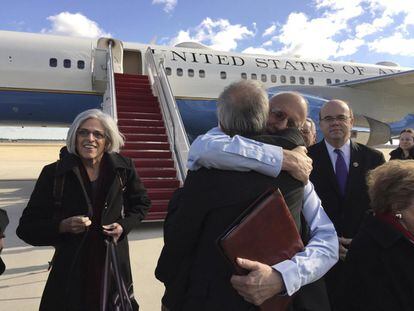 Alan Gross abraza a Tim Rieser (de espalda), un miembro de la oficina del senador Patrick Leahy, en la pista mientras desembarca de un avión del gobierno de Estados Unidos con su esposa Judy en la Base Conjunta Andrews en Maryland en las afueras de Washington.