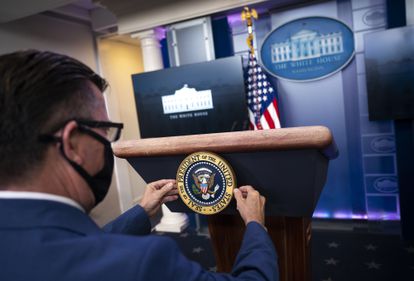 Un miembro de Comunicación de la Casa Blanca coloca el sello presidencial antes de una rueda de prensa de Donald Trump, el pasado 24 de noviembre.
