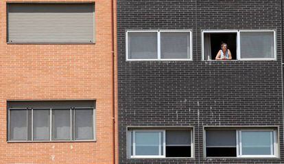 Una vecina se asoma a una ventana del edificio Memoria, de la EMVS, en la calle de Barrileros.